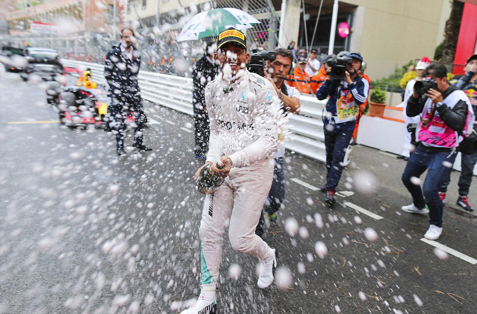 Lewis Hamilton pops his victory champagne (Credit: EPA)