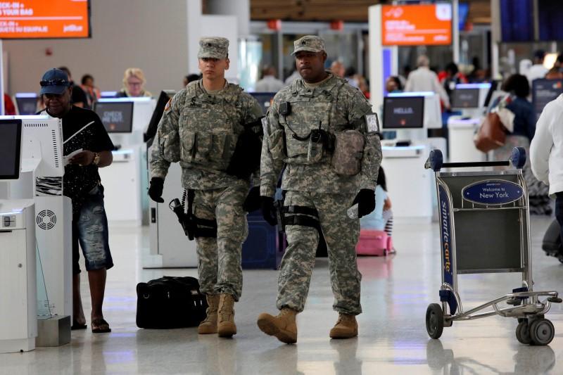 US Army personnel monitor the Departures area of the airport after the reported threat. (Photo: Reuters/Andrew Kelly)