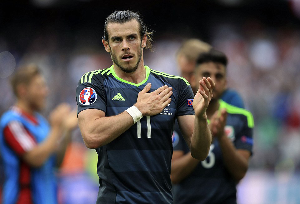 A sad Bale presses his hand against his nation's crest to salute the Welsh fans (Photo: PA)